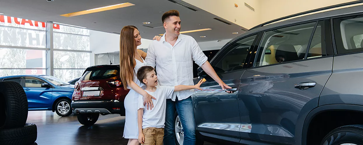 Family looking at a new vehicle at a car dealership