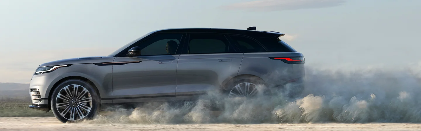 2026 Range Rover Velar driving on a dirt road with dust flying in the air