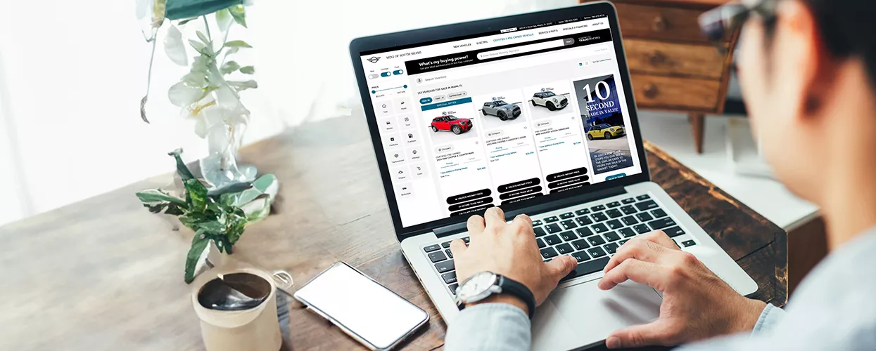 A person browsing the dealerships inventory on a laptop