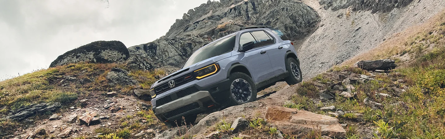 Gray 2026 Honda Passport driving down a rocky hill