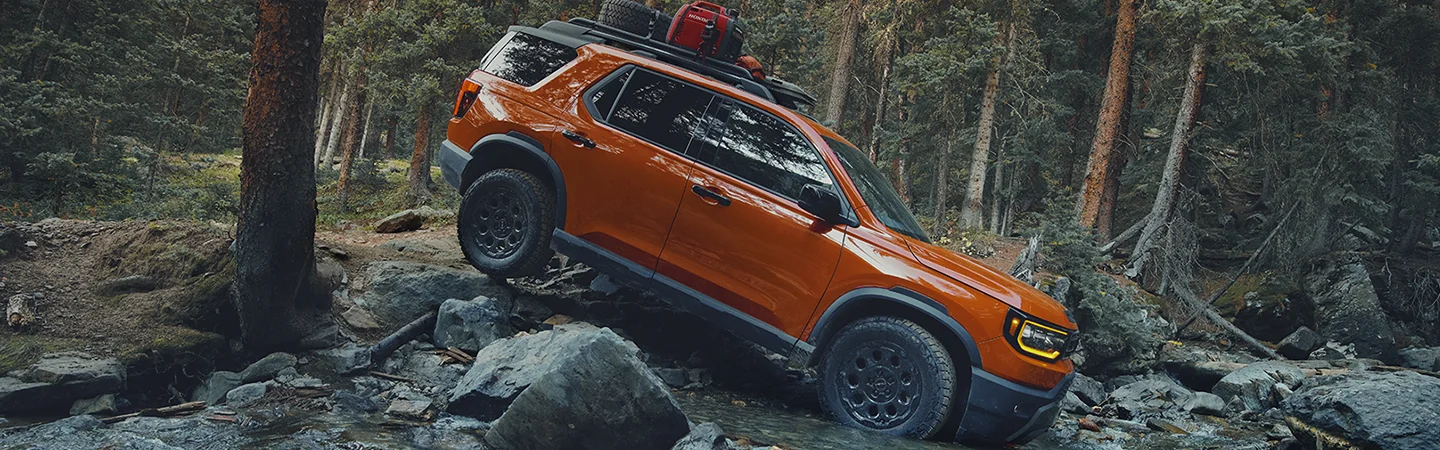 Orage 2026 Honda Passport driving though the river in the woods