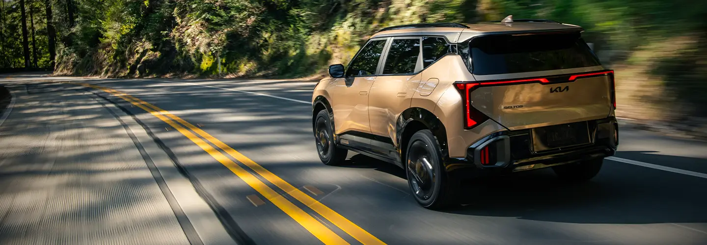 rear of Gold 2027 Kia Seltos on the road