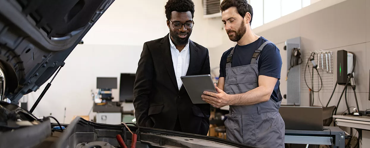 Service mechanic talking to a customer about their vehicle