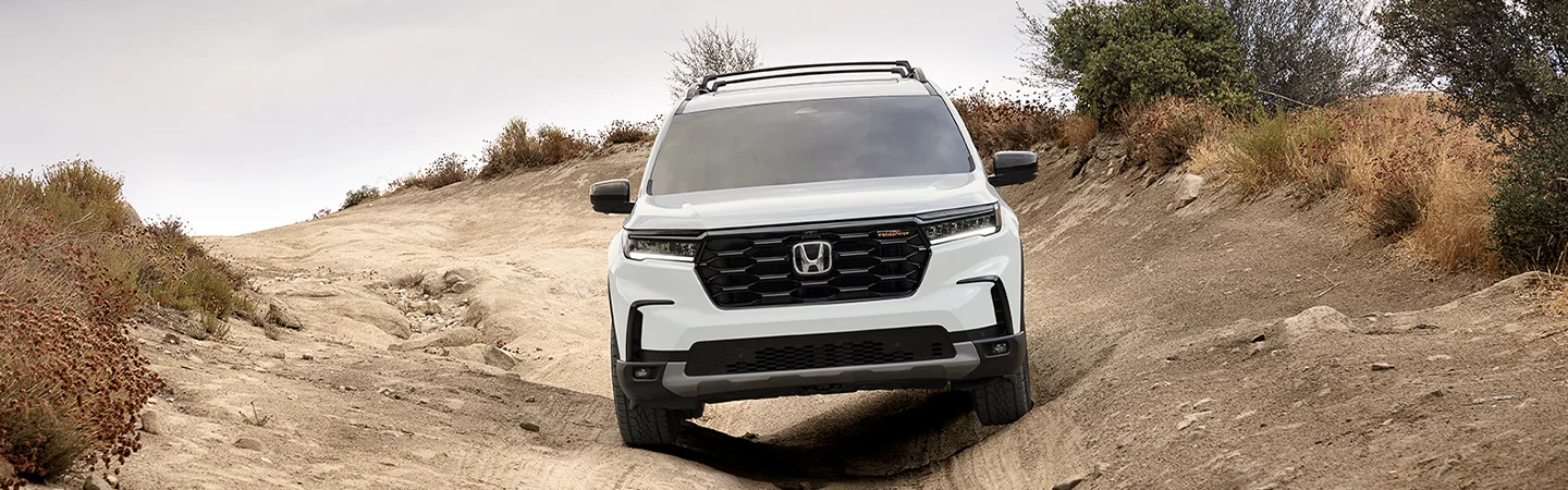 2025 Honda Pilot vs Toyota Highlander white color car stand on hill road