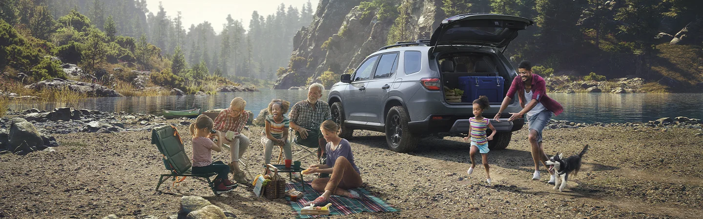 2025 Honda Pilot vs Toyota Highlander dark silver color Car parked at picnic spot in forest and family enjoying picnic