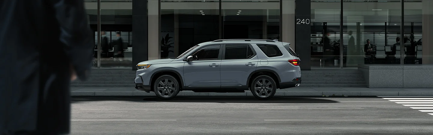 2025 Honda Pilot vs Toyota Highlander dark silver color car stand on city