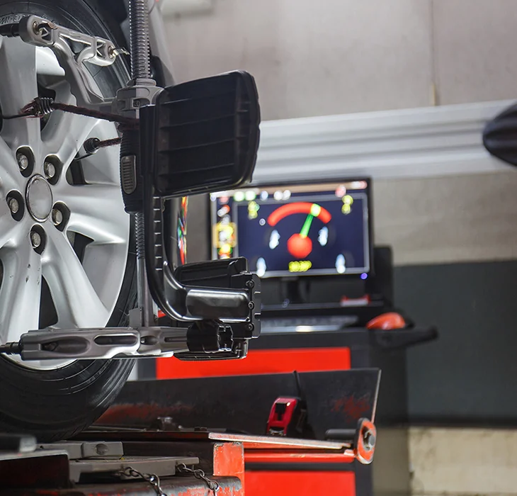 mechanic in the shop room running a diagnosis of a vehicle on the computer