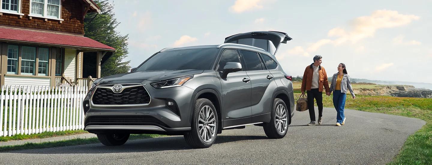 couple approaching a 2025 Toyota Highlander Hybrid after a picnic