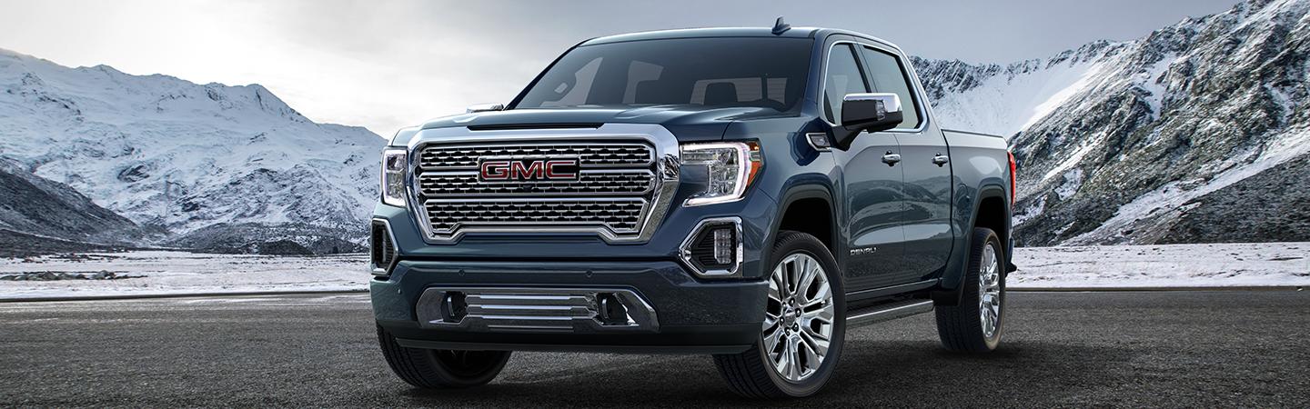 BLUE 2021 GMC SIERRA PARKED BY MOUNTAINS