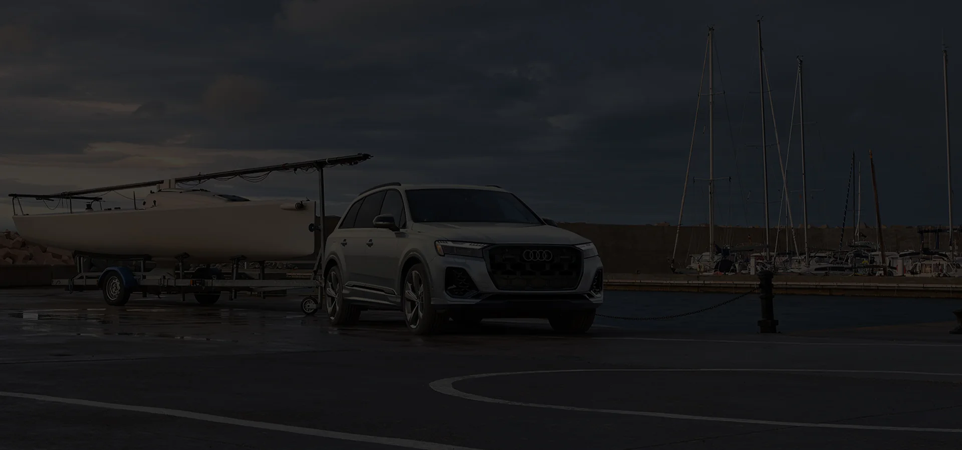 A car parked in a parking lot adjacent to a boat, showcasing a typical recreational vehicle setup.