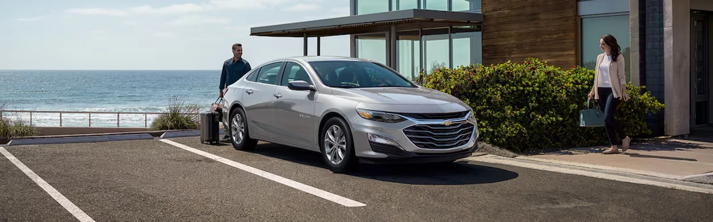 Front view of a parked 2025 Chevrolet Malibu in front of a beach house