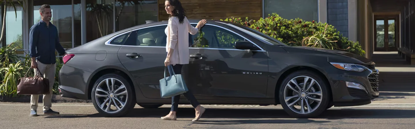 Side view of a parked 2025 Chevrolet Malibu in front of a house