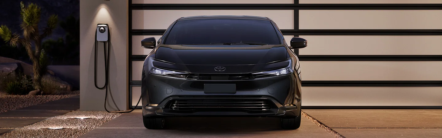 Front view of a black 2026 Toyota Prius parked in the driveway charging