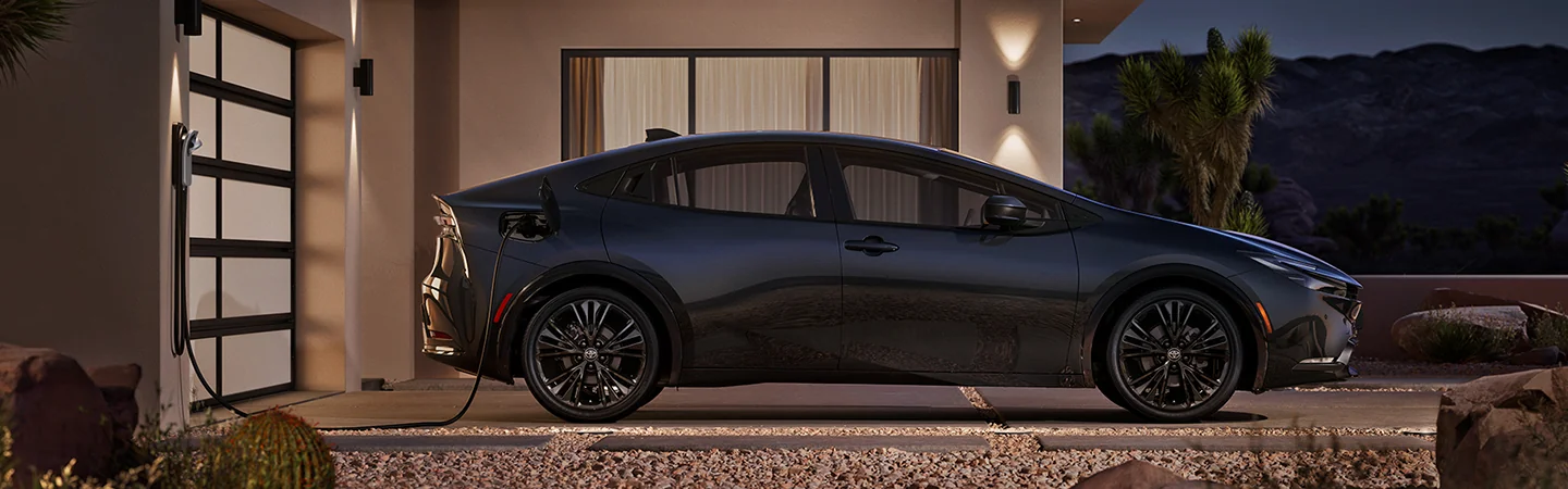 Side view of a gray 2026 Toyota Prius parked at a home changing