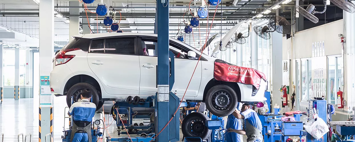 A white Toyota SUV being worked on in the service shop