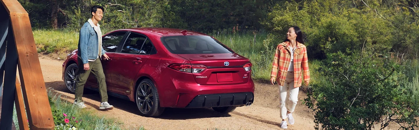 The back of a parked red 2024 Toyota Corolla in the woods