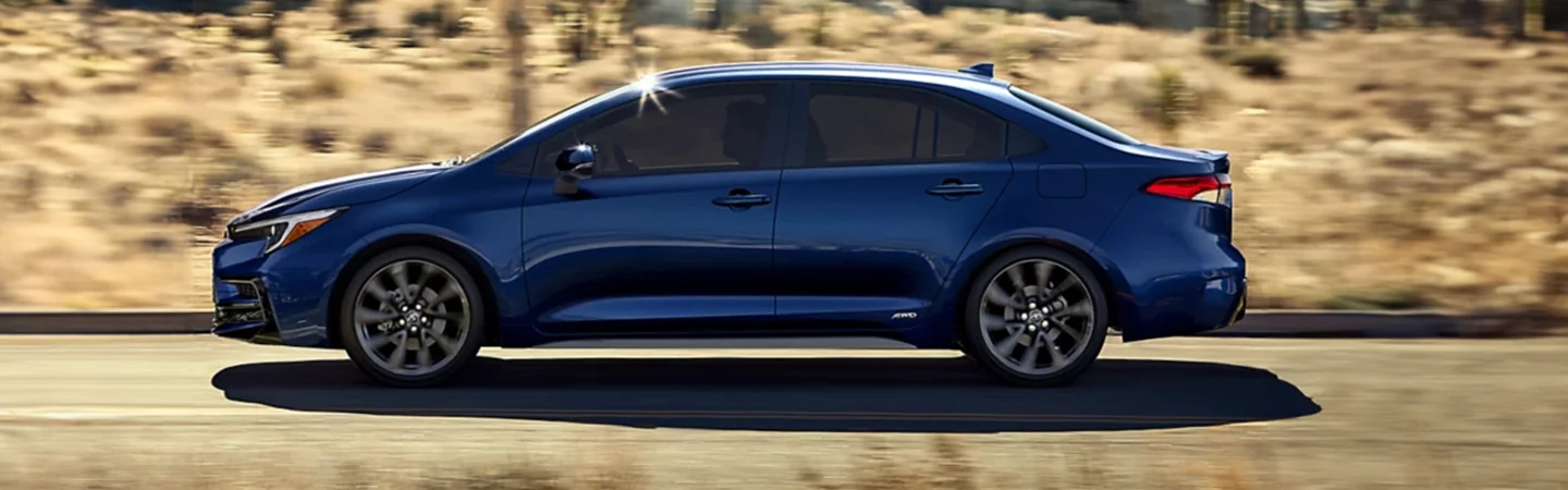 Side view of a blue 2024 Toyota Corolla driing on the road