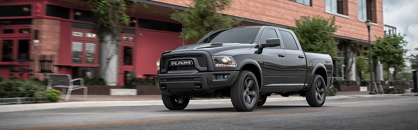 Front view of a black 2021 RAM 1500 driving down the road.