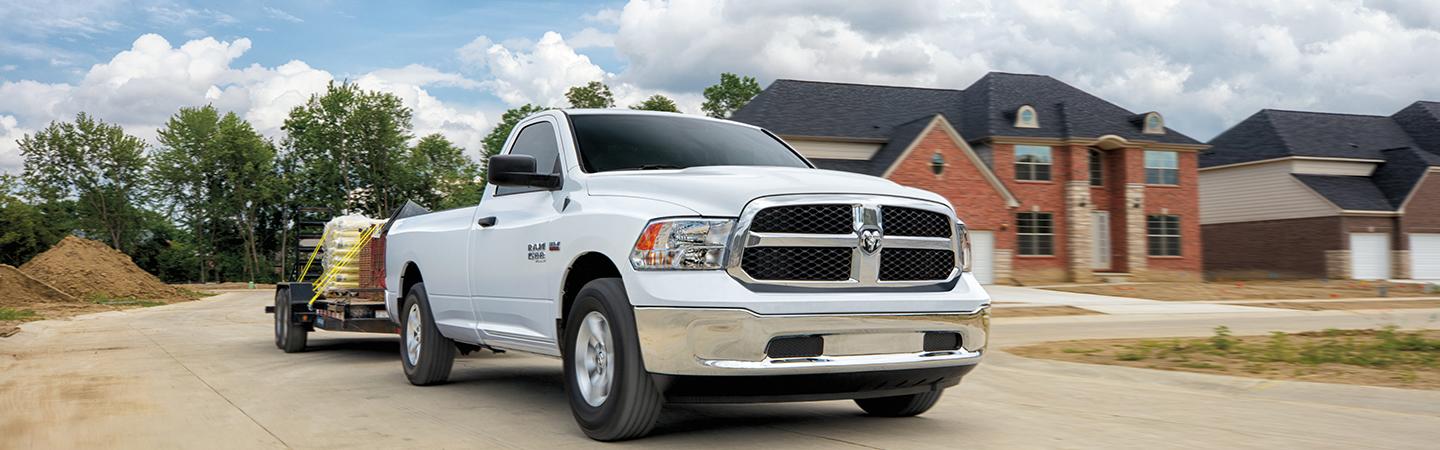 White 2021 RAM 1500 towing a trailer.