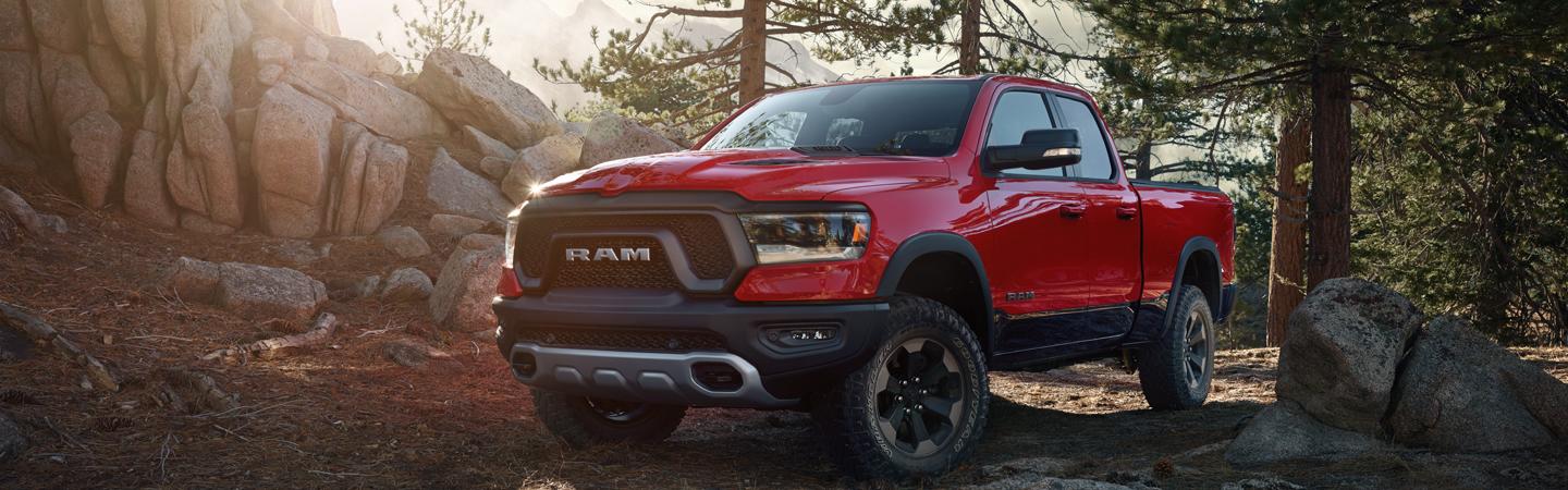 Front view of a red 2021 RAM 1500 parked in the woods.