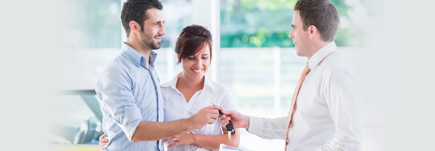 A couple being handed new car keys