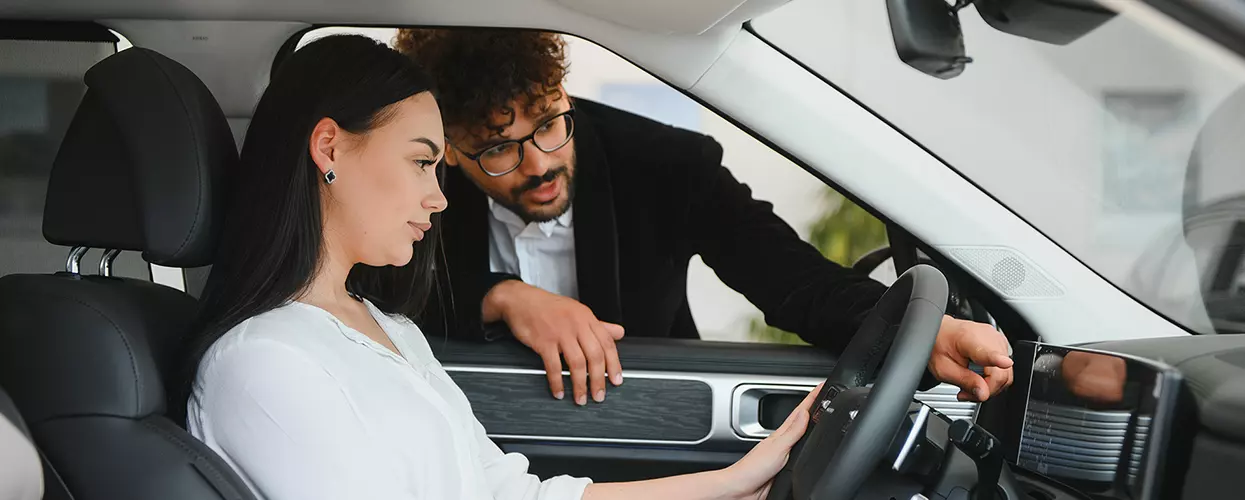 Car salesman showing a customer the interior of a car