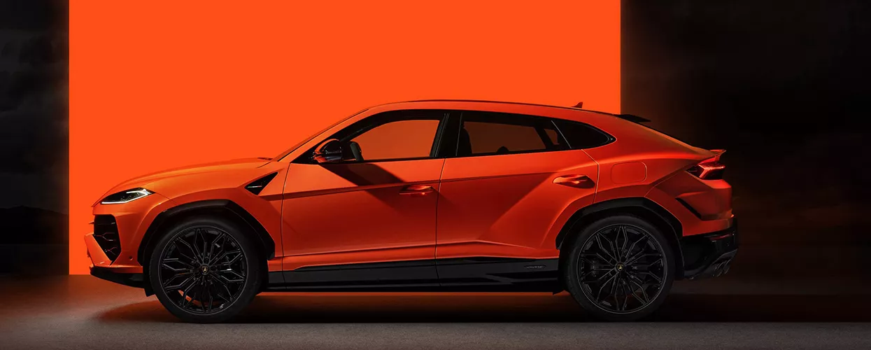 Orange Lamborghini Urus luxury performance SUV side profile with black wheels and sporty coupe-style design