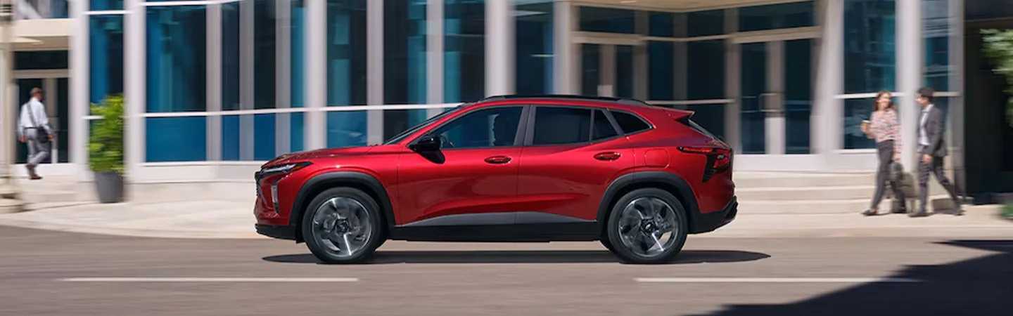 A red 2025 Chevrolet Trax driving in the city