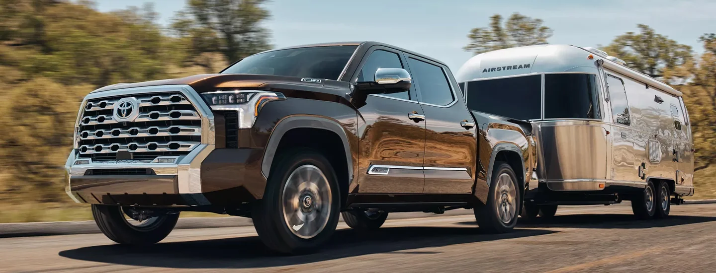 A 2025 Toyota Tundra pulling a trailer on a road
