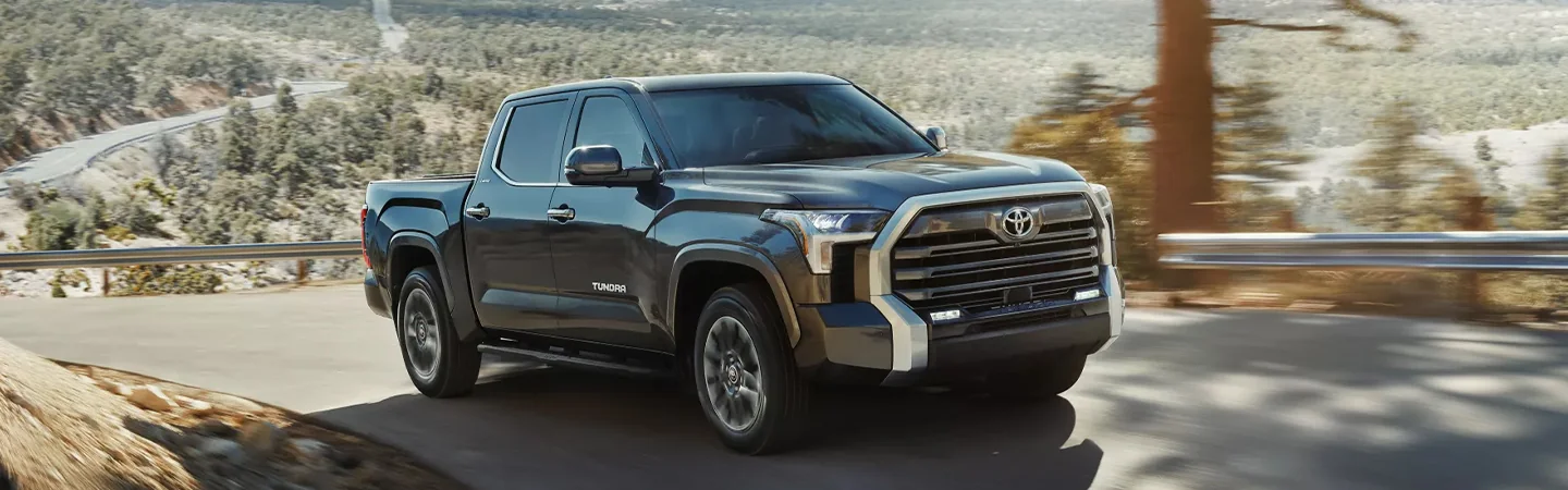 A side view foa 2025 Toyota Tundra driving in the wilderness