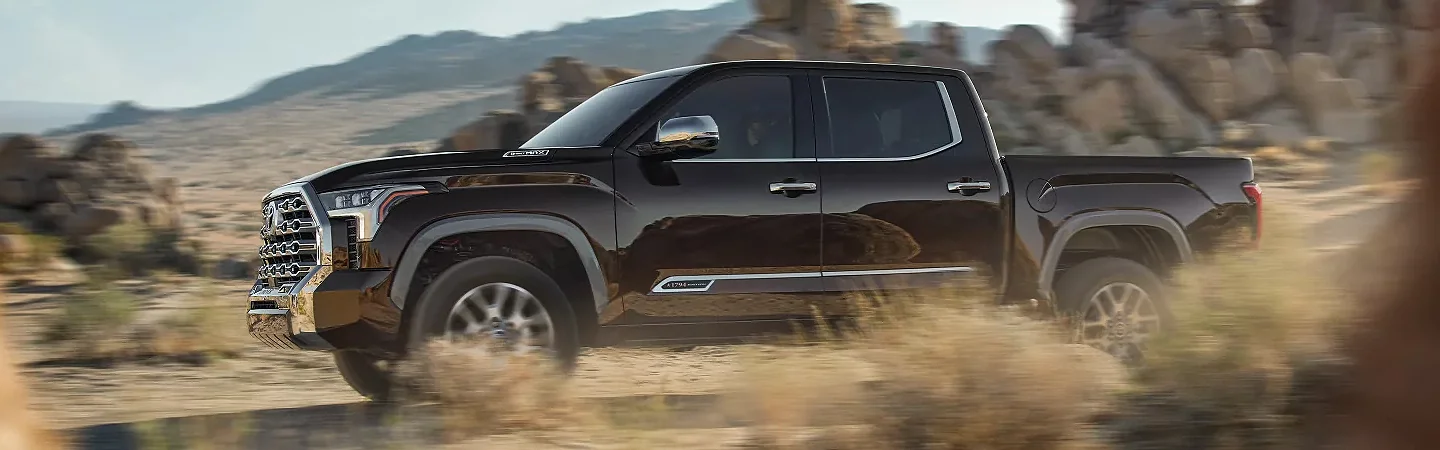 Side view of a black 2025 Toyota Tundra driving in the desert