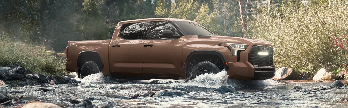A brown 2025 Toyota Tundra driving in a river