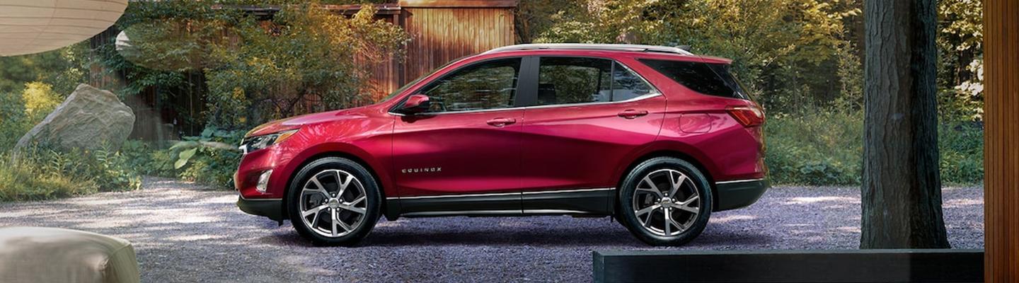 Side profile of a parked red Chevy Equinox