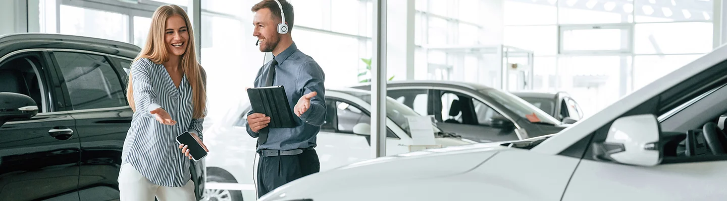 2 people looking over car