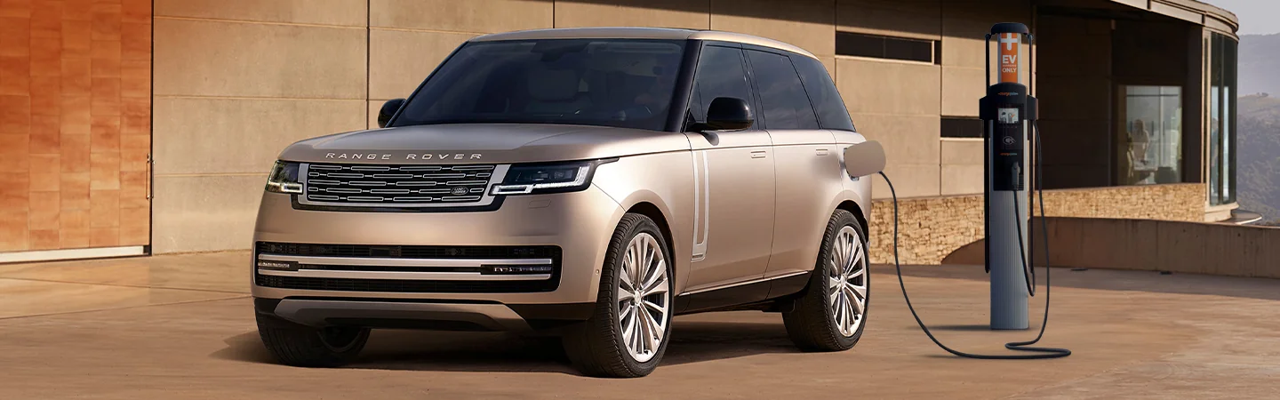 2025 Range Rover Hybrid parked in front of a house charging