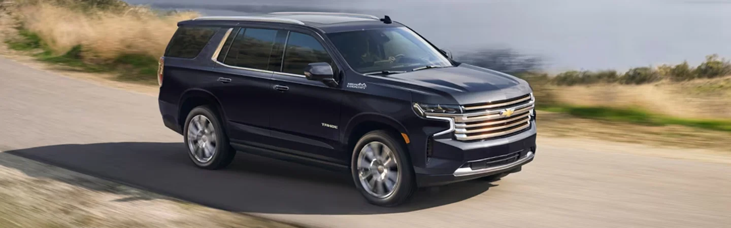 A black 2024 Chevrolet Tahoe driving down the road
