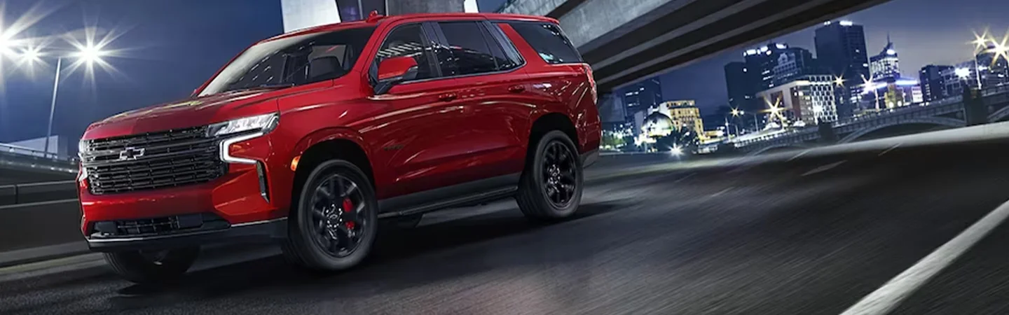 A red 2024 Chevrolet Tahoe driving in the city
