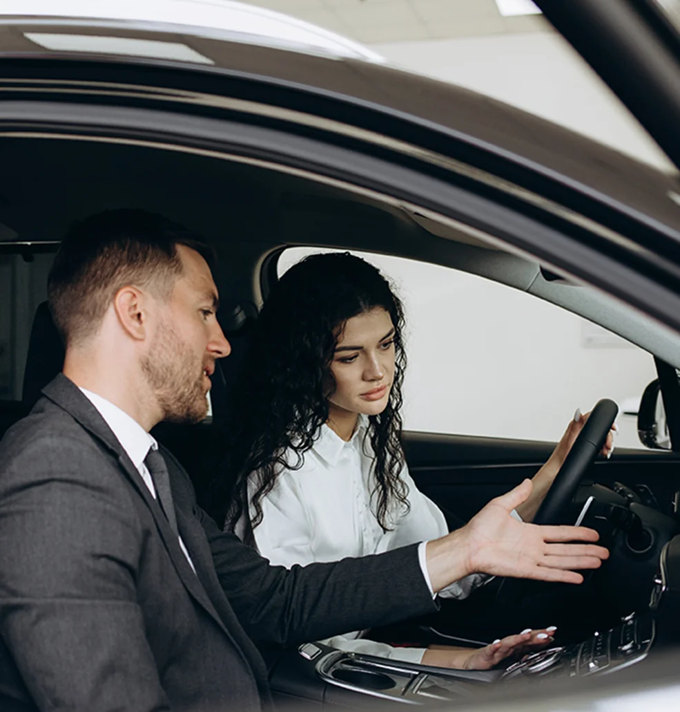 A sales person showing a customer the features inside a new Hyundai Elantra