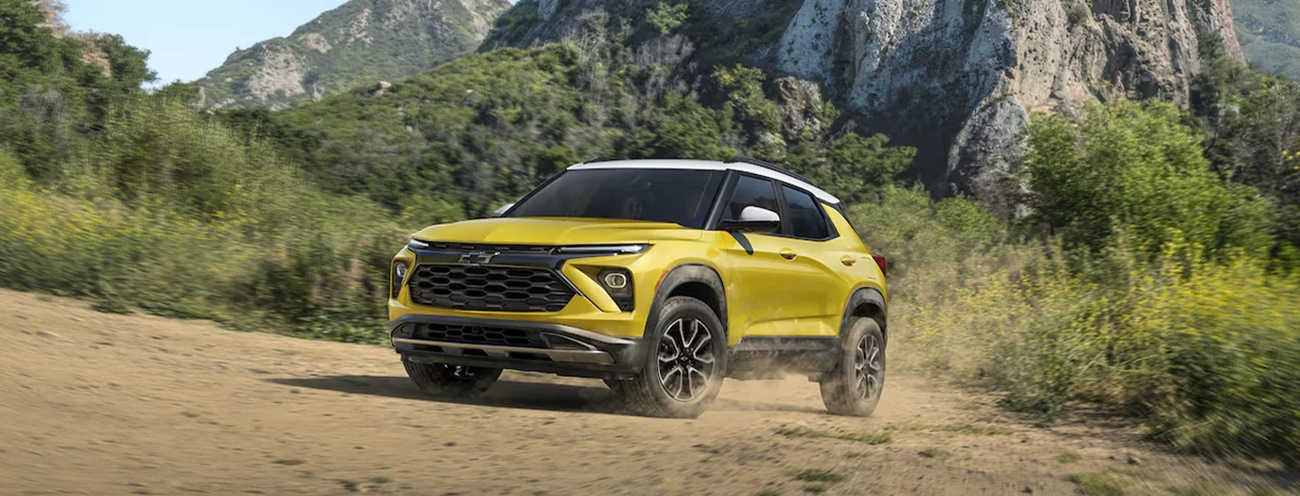 A yellow 2025 Chevrolet Trailblazer driving in the wilderness