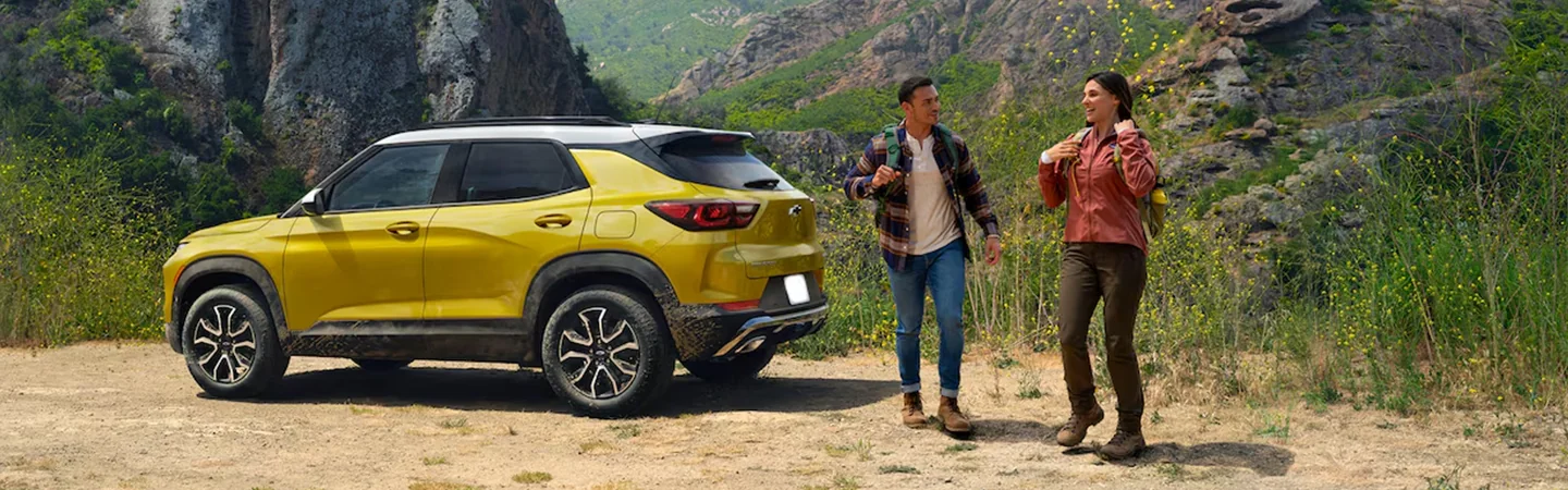 Side view of a parked yellow 2025 Chevrolet Trailblazer in the wilderness