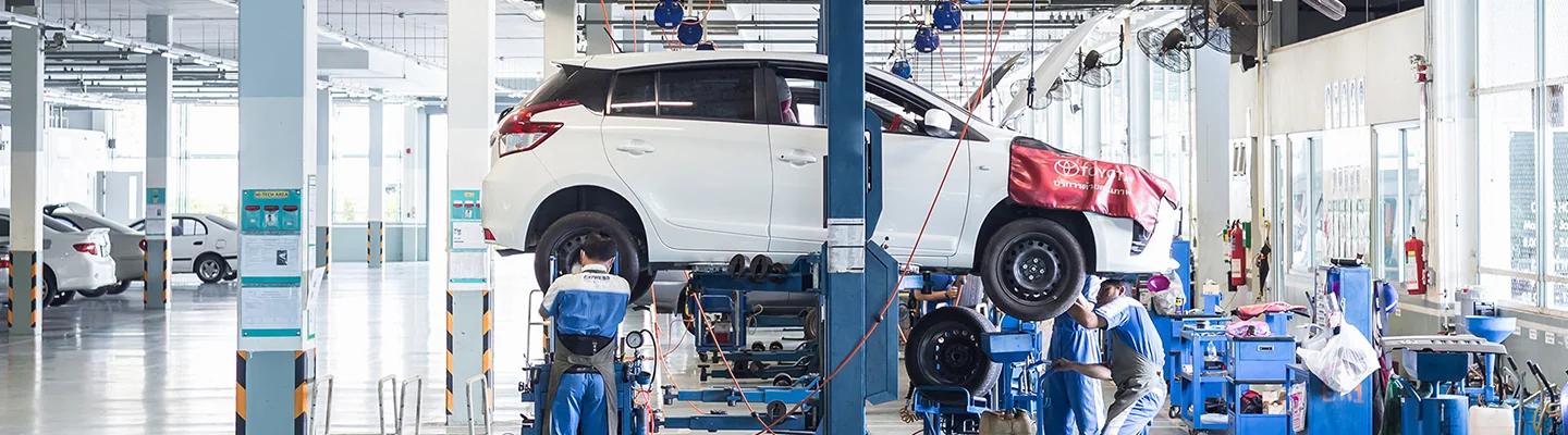 A vehicle on a lift in the service bay area of a Toyota dealership