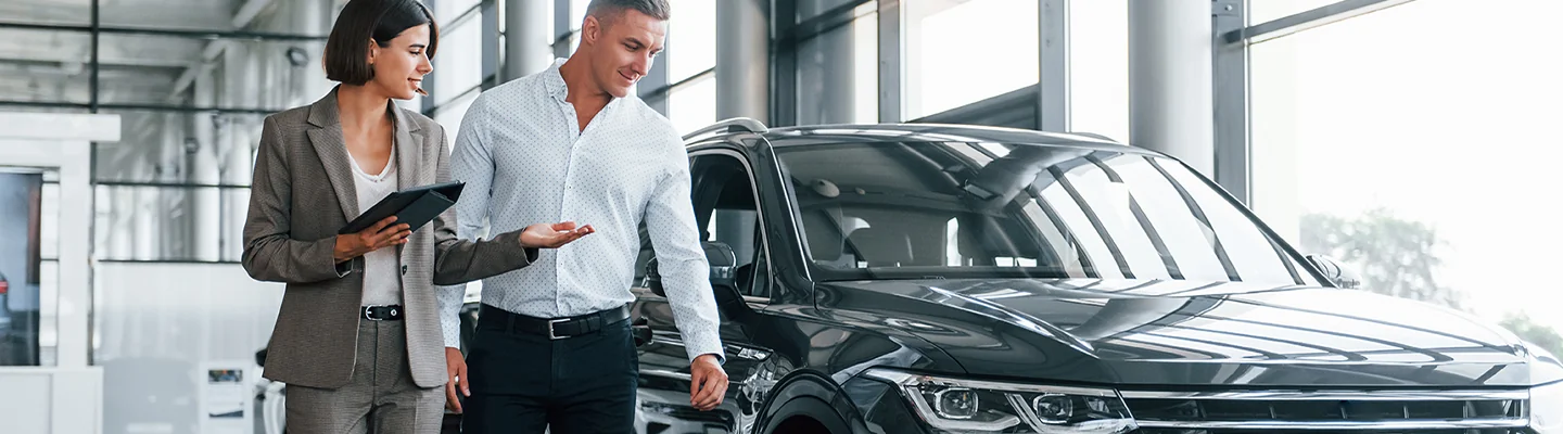 People looking at a Vehicle at a dealership