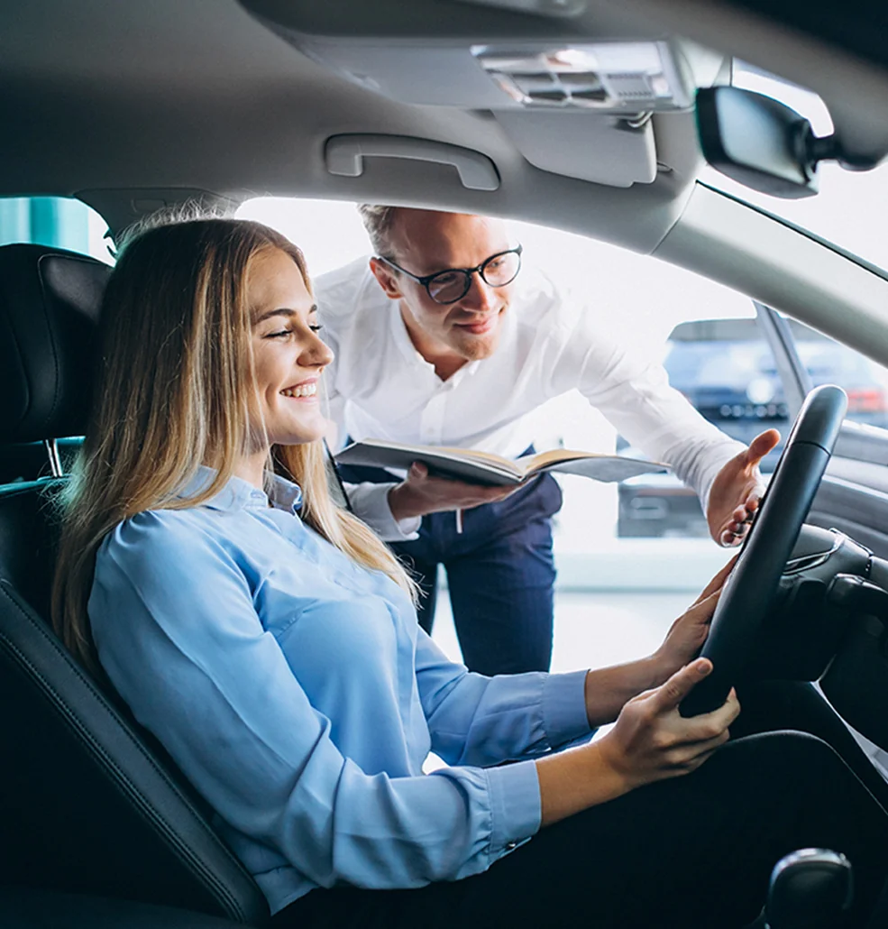 Sales person showing customer the inside of a new car