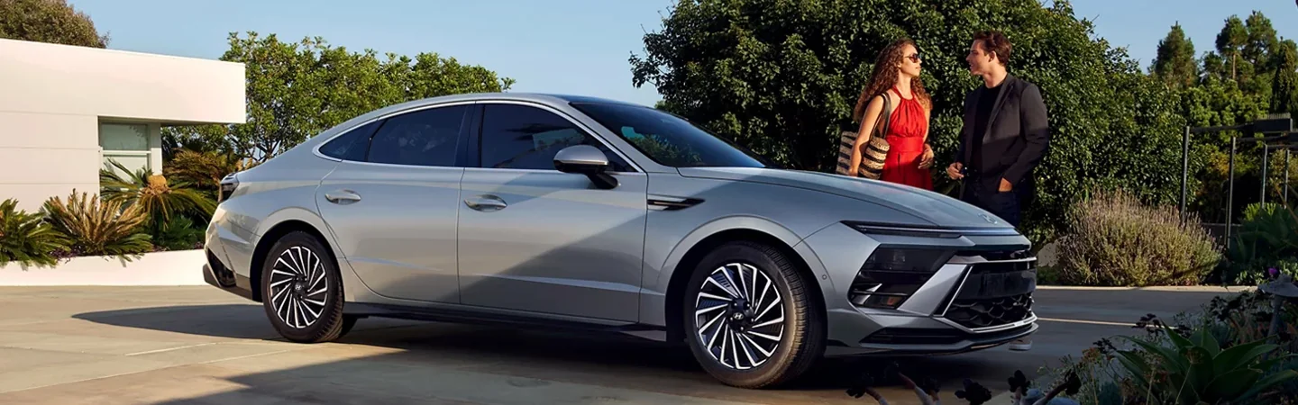 Hyundai Sonata Hybrid parked with woman walking away