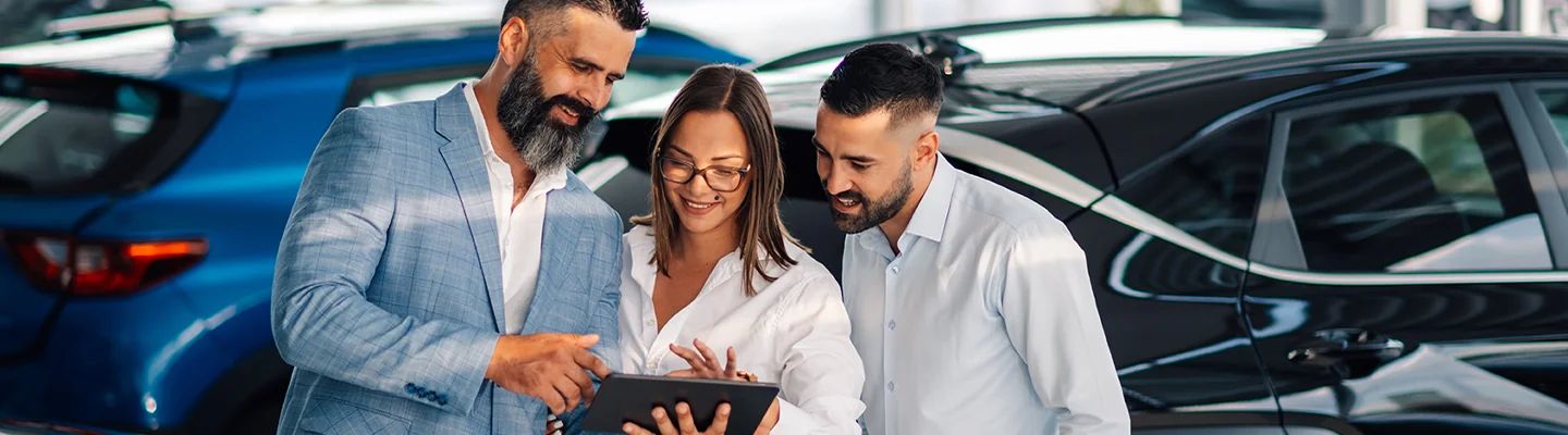 Sales person helping customer with car info on a tablet