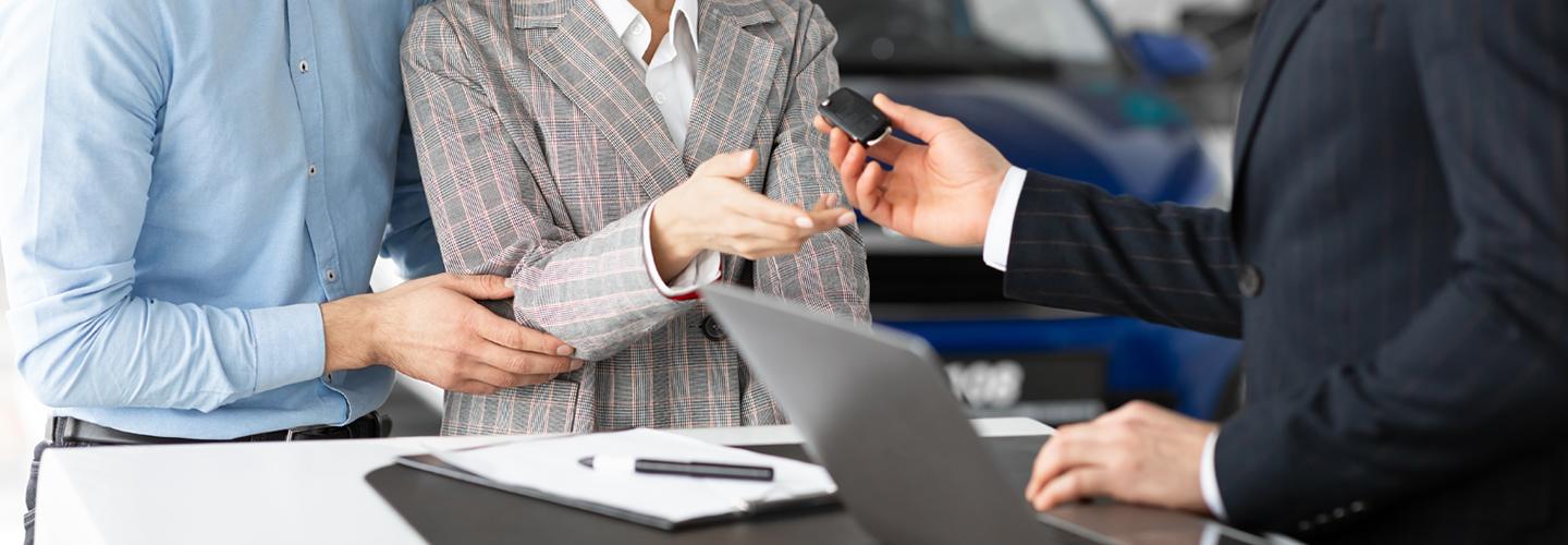 Sales person handing over new car keys