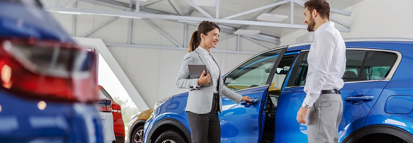 Sales person open the door for a customer to get into there new car