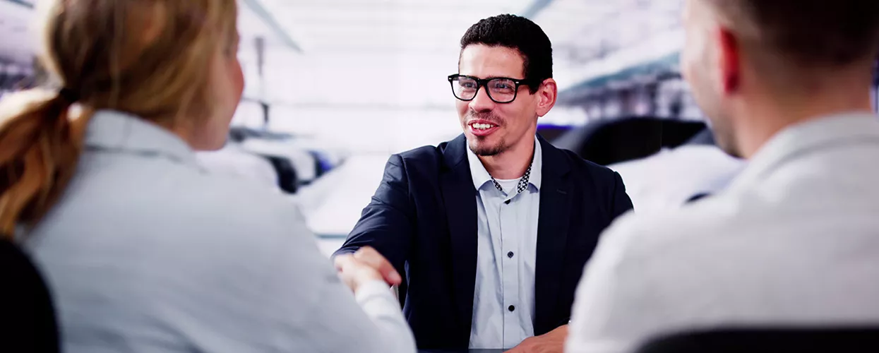 Car salesman talking to a customer in a dealership
