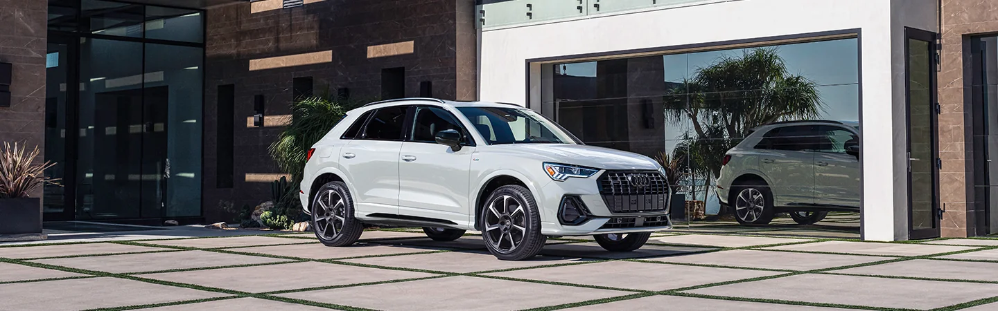 Front side view of a 2025 Audi Q3 parked next to a building