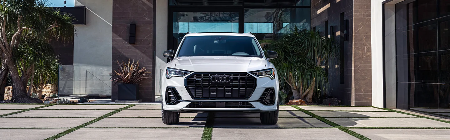 Front view of a white 2025 Audi Q3 parked in a driveway